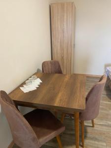 uma mesa de jantar com cadeiras e uma mesa de madeira em LUX apartmani za izdavanje em Bečej