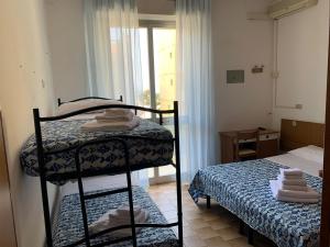 pokój z łóżkiem i pokój z łóżkiem piętrowym w obiekcie Hotel Estense w Rimini