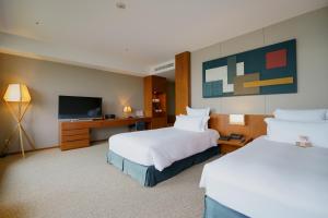 um quarto de hotel com duas camas e uma televisão de ecrã plano em Bella Vista Spa and Marina ONOMICHI em Onomichi