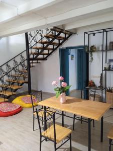 a room with a table and a spiral staircase at Qiwi House in Ureki