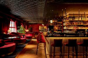 a bar with red chairs and a bar counter at Provocateur Berlin, part of Sircle Collection in Berlin +51 photos