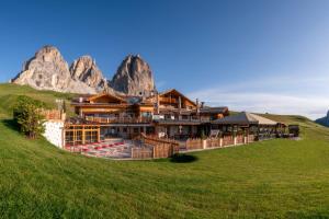 カナツェーイにあるRifugio Saleiの山を背景にした丘の上のホテル