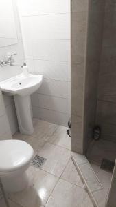 a bathroom with a sink and a toilet and a shower at City Hostel in Skopje