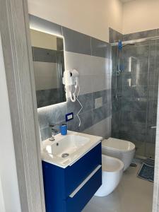 y baño con lavabo azul y aseo. en VistAmare - Fuscaldo, en Marina di Fuscaldo