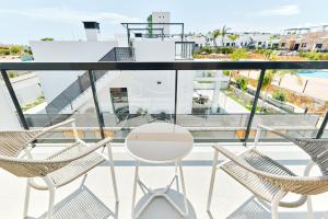 a balcony with two chairs and a white table at Apartment Comfort Zone 2 in Pilar de la Horadada +76 photos