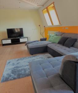 a living room with a couch and a flat screen tv at Appartement Jakalar in Vils