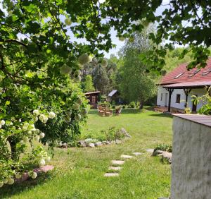 a yard with a house and a garden with a pathway at Ostoja Leśna Cisza in Purda