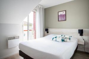 ein Schlafzimmer mit einem großen Bett und einem Fenster in der Unterkunft Zenitude Hôtel-Résidences Nantes - La Beaujoire in Nantes