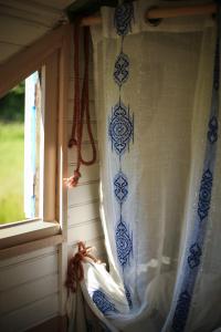 a window with blue and white curtains in a room at la Pangée roulottes hébergements insolites in Lansac