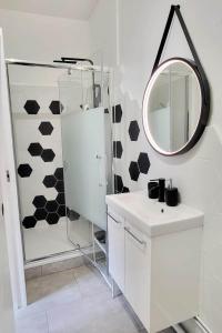 W łazience znajduje się biała umywalka i lustro. w obiekcie Le Cocon de Reims /Wifi/Commerce /Av de Paris w mieście Reims