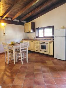 a kitchen with a table and a white refrigerator at Gallipoli lato sudChalet Pesco in Taviano