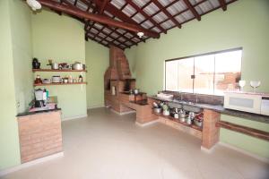 uma grande cozinha com um forno de tijolos num quarto em Chacara c piscina e vista para Cach dos PretosSP em Joanópolis