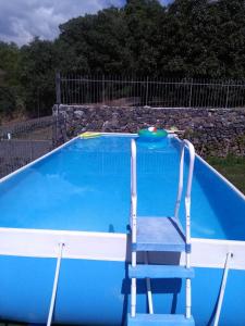 a blue and white pool with a chair and aogie board at Ai tre archi in Mascali