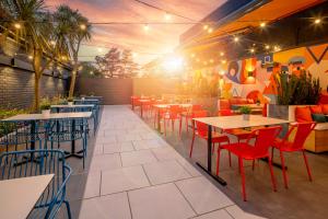 een restaurant met tafels en stoelen en een muur bij Holiday Inn Southampton Eastleigh, an IHG Hotel in Eastleigh