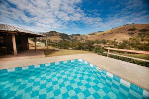 uma piscina com vista para uma montanha em Chacara c piscina e vista para Cach dos PretosSP em Joanópolis