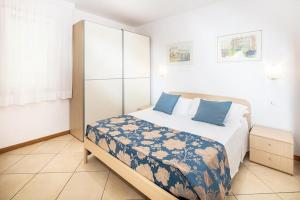 a bedroom with a large bed with blue pillows at Appartamenti Aurora in Bibione