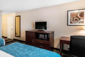 a hotel room with a bed and a flat screen tv at Oasis Inn Tacoma in Tacoma