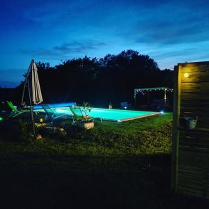 una piscina iluminada por la noche en La hulotte de Labarthe, en Mazères