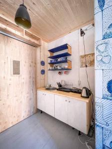 eine Küche mit weißen Schränken und einer Holzdecke in der Unterkunft Fairytale apartment in Viljandi old town in Viljandi