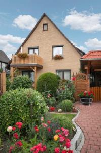 uma casa com um jardim com flores e um passadiço de tijolos em Ferienwohnung Regner em Bad Bevensen