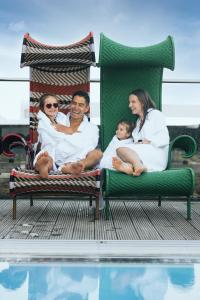 a family sitting on a bed next to a pool at Clarion Hotel Arlanda Airport Terminal in Arlanda