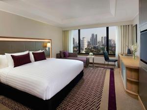pokój hotelowy z dużym łóżkiem i dużym oknem w obiekcie Grand Mercure Bangkok Atrium w mieście Bangkok