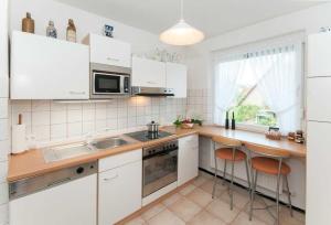 cocina con armarios blancos y encimera de madera en Ferienwohnung Regner en Bad Bevensen