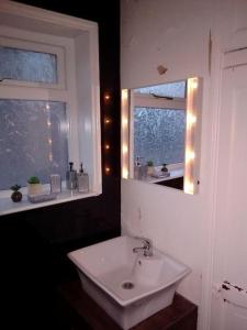 a bathroom with a white sink and a mirror at Blackpool Holiday Home - Forshaw House in Blackpool