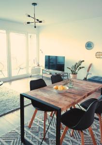 ein Esszimmer mit einem Holztisch und Stühlen in der Unterkunft Apartment mit Balkon - Netflix - nahe Messe Düsseldorf in Krefeld