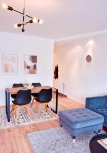 ein Wohnzimmer mit einem Tisch, Stühlen und einem Sofa in der Unterkunft Apartment mit Balkon - Netflix - nahe Messe Düsseldorf in Krefeld