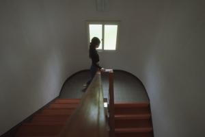 a woman is walking down a stairway at Hotel 2YL Atami in Atami