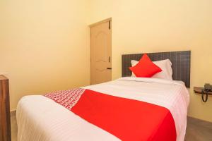 un letto rosso e bianco in una stanza di OYO Flagship 28067 Shree Stays a Bangalore