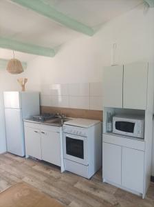 una cocina con electrodomésticos blancos y armarios blancos en 7-gîte-7 personnes au cœur de la nature /piscine, en Saint-Aubin-de-Nabirat