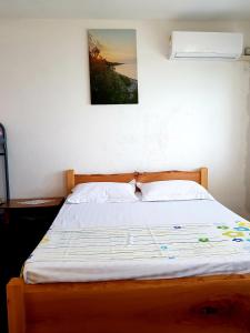 1 cama en un dormitorio con una foto en la pared en B&B BALANI Rooms, en Shkodër