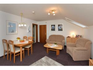 a living room with a table and chairs and a couch at Ferienwohnungen Haus Bahlo in Bad Bevensen +5 photos