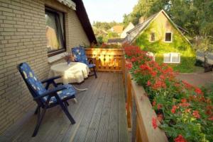 un patio con 2 sillas, una mesa y flores en Ferienwohnungen Haus Bahlo en Bad Bevensen