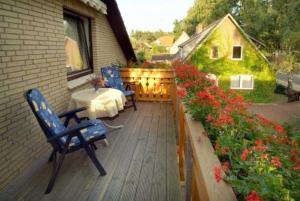 a patio with two chairs and a table and flowers at Ferienwohnungen Haus Bahlo in Bad Bevensen