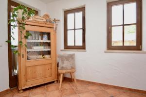 a chair in a room with a cabinet and windows at Appartement Oberschernthann in Hopfgarten im Brixental