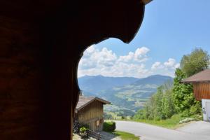 dziura w boku budynku z widokiem na góry w obiekcie Appartement Oberschernthann w mieście Hopfgarten im Brixental