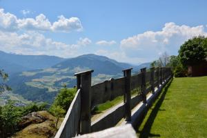 una cerca en una colina con montañas en el fondo en Appartement Oberschernthann, en Hopfgarten im Brixental