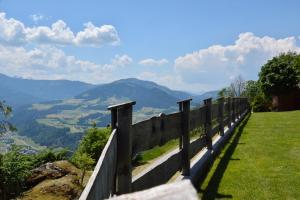 a fence on a hill with mountains in the background at Appartement Oberschernthann in Hopfgarten im Brixental