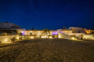 a night view of a house with lights at Athiri Luxury Suites in Perivolos