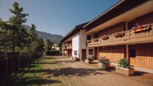 a courtyard of a building with flowers on the balconies at Rottach Apartments - Ferienwohnungen am Tegernsee in Rottach-Egern