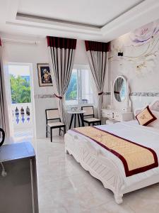 Godiva Villa Phu Quoc في فو كووك: غرفة نوم بسرير وطاولة وكراسي