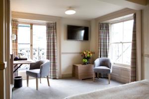 a bedroom with a desk and two chairs and a table at Royal Ship in Dolgellau