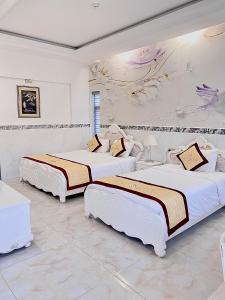 two beds in a room with white walls at Godiva Villa Phu Quoc in Phu Quoc