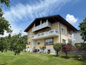 ein großes gelbes Gebäude mit Balkon auf einem Hof in der Unterkunft Feistritzer in Seeboden