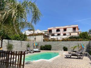 a swimming pool with two chairs and a house at Anirè - Case Vacanze in Taranto