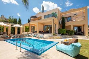 a villa with a swimming pool in front of a house at Villa Serena, Eastern Corfu in Kato Korakiana