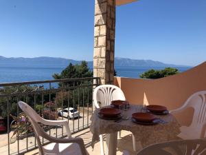 a table on a balcony with a view of the ocean at Apartments PEHAR in Podaca